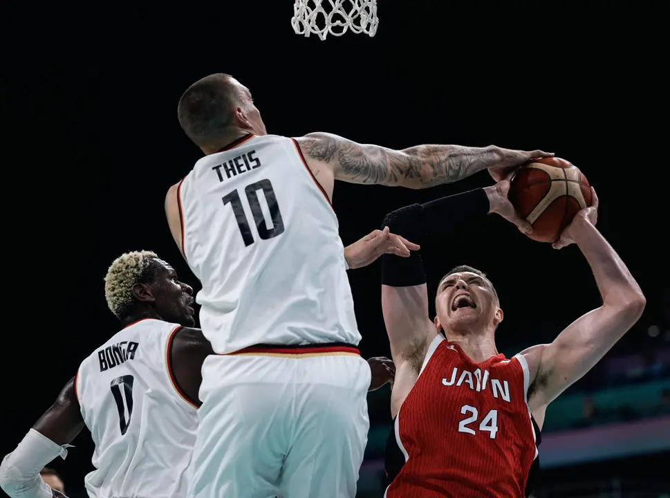 El jugador japon&eacute;s Josh Hawkinson (d) en acci&oacute;n abte los alemanes Isaac Bonga (I) y Daniel Theis en el Pierre Mauroy Stadium en Villeneuve-d'Ascq, Francia. EFE/EPA/ALEX PLAVEVSKI