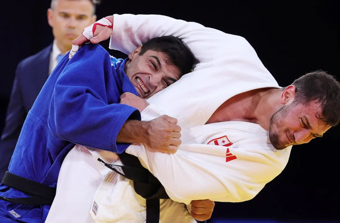 El georgiano Lasha Bekauri (blanco) y el espa&ntilde;ol Tristani Mosakhlishvili (azul) en acci&oacute;n durante el combate de -90kg en los Campos de Marte de Par&iacute;s, Francia. EFE/EPA/TERESA SUAREZ