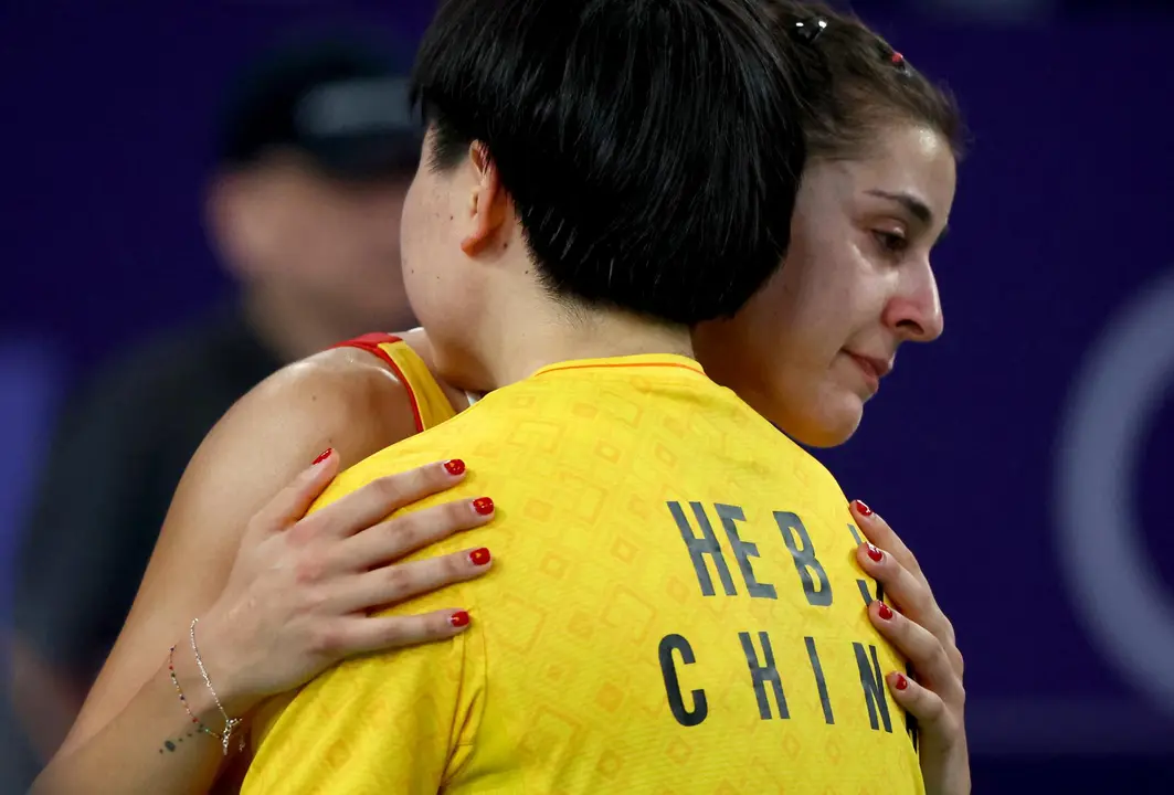 Carolina Mar&iacute;n abraza a su oponente He Bing Jiao de China tras retirarse con una lesi&oacute;n de la semifinal ol&iacute;mpica. EFE/EPA/DIVYAKANT SOLANKI