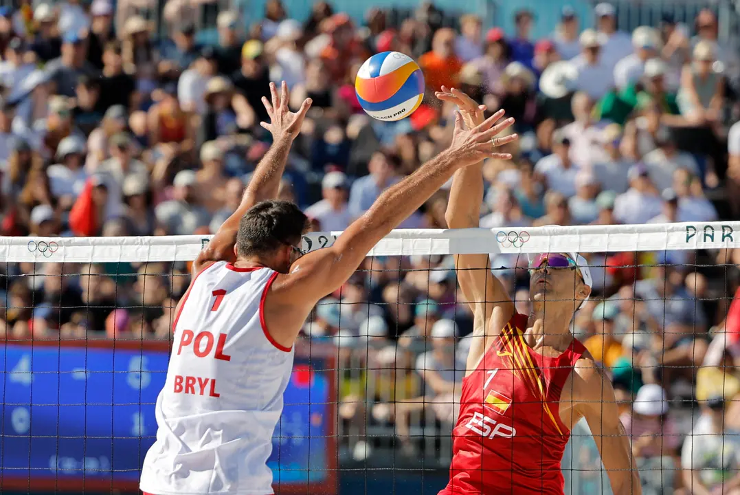 El espa&ntilde;ol Pablo Herrera (d) durante el partido de octavos de final del torneo ol&iacute;mpico de voley playa masculino contra los polacos Michal Bryl (i, de espaldas) y Bartosz Losiak. EFE/Lavandeira Jr