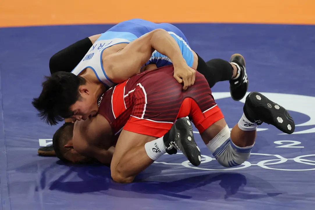 El luchador venezolano Jose Rodriguez Orozo Raiber (rojo) en su combate ante el norcoreano Ri se Ung (azul) en su combate por la medalla de bronce de Lucha Grecorromana, 60 kg, de los Juegos Ol&iacute;mpicos Par&iacute;s 2024, en la capital gala. EFE/ Miguel Guti&eacute;rrez