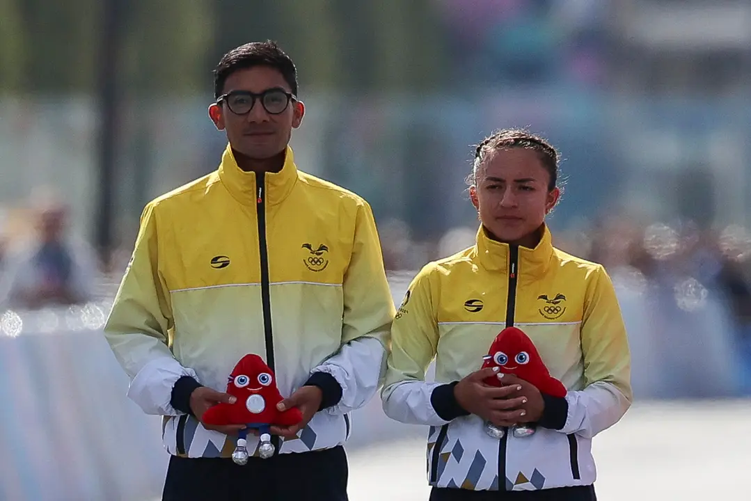 Los atletas ecuatorianos Brian Daniel Pintado (i) y Glenda Morej&oacute;n (2i) posan tras ganar la plata en la prueba de marat&oacute;n mixto de marcha. EFE/ Miguel Guti&eacute;rrez