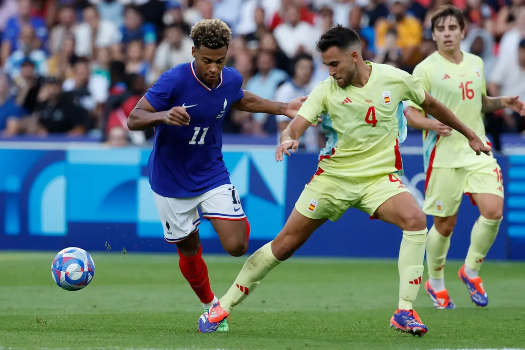 El jugador franc&eacute;s Desir&eacute; Doue (i) disputa un bal&oacute;n ante el jugador espa&ntilde;ol Eric Garc&iacute;a durante la prorroga del partido por la medalla de oro de los Juegos Ol&iacute;mpicos de Par&iacute;s 2024 que Francia y Espa&ntilde;a disputan este viernes en el Parc des Princes, de Paris . EFE/ JUANJO MARTIN