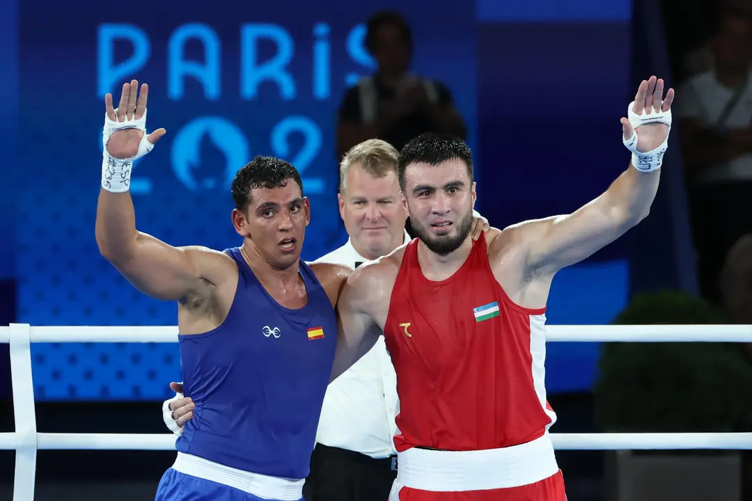 El boxeador uzbeko Bahodir Jalolov vence al espa&ntilde;ol Ayoub Ghadfa (azul) tras el combate por la medalla de oro de Boxeo +92 kg masculino, de los Juegos Ol&iacute;mpicos de Par&iacute;s 2024 este s&aacute;bado, en el Estadio Roland-Garros de la capital gala. EFE/ Kiko Huesca