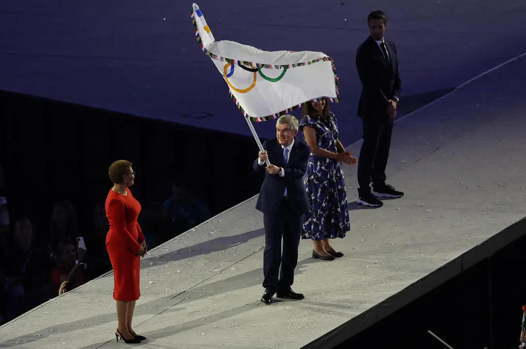 La alcaldesa de Los Angeles, Karen Bass (i), recibe la bandera ol&iacute;mpica de manos del presidente del COI, Thomas Bach (c), durante la ceremonia de clausura de los Juegos Ol&iacute;mpicos de Par&iacute;s 2024 celebrada en el Estadio de Francia en Saint-Denis. EFE/ Miguel Guti&eacute;rrez