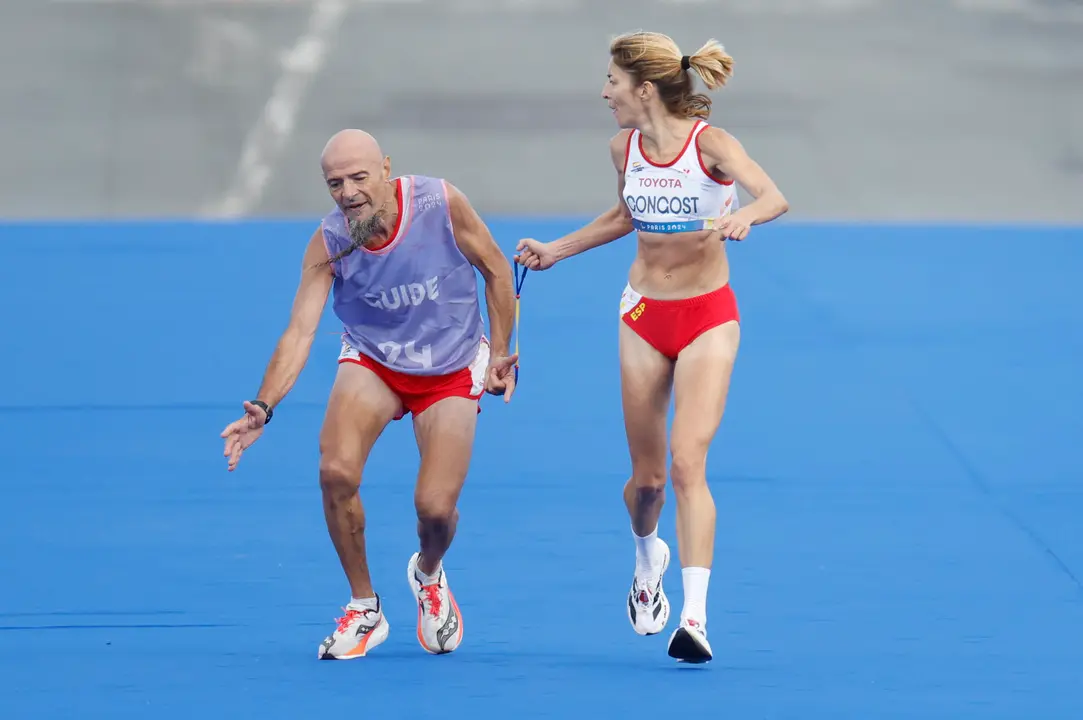 La atleta espa&ntilde;ola Elena Congost, medalla de bronce en la final de la marat&oacute;n T12 femenino, ayuda a su gu&iacute;a, que llega exhausto a la l&iacute;nea de meta en los Juegos Paral&iacute;mpicos de Par&iacute;s 2024. EFE/ Javier Etxezarreta
